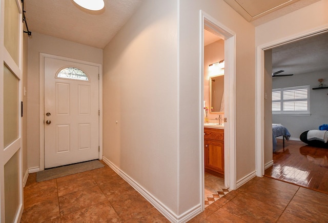 5521 Rosewood Dr, Galveston, TX 77551 - doorway to outside with baseboards and a textured ceiling