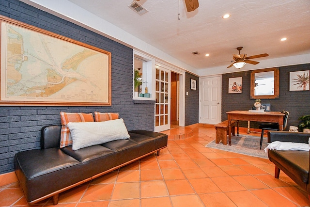 5521 Rosewood Dr, Galveston, TX 77551 - living area featuring tile patterned flooring, a ceiling fan, and brick wall