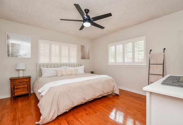 5521 Rosewood Dr, Galveston, TX 77551 - bedroom with baseboards, light wood-style flooring, and a ceiling fan