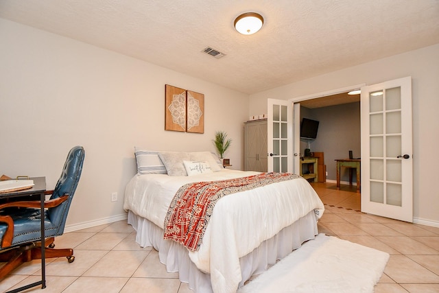 5521 Rosewood Dr, Galveston, TX 77551 - bedroom with french doors, a textured ceiling, light tile patterned floors, baseboards, and visible vents