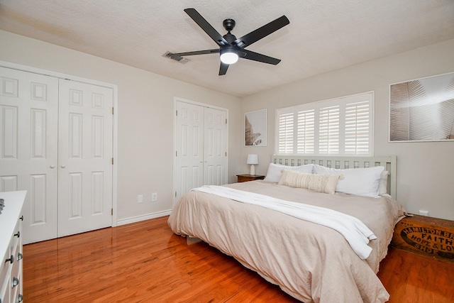 5521 Rosewood Dr, Galveston, TX 77551 - bedroom with a ceiling fan, light wood finished floors, baseboards, visible vents, and two closets