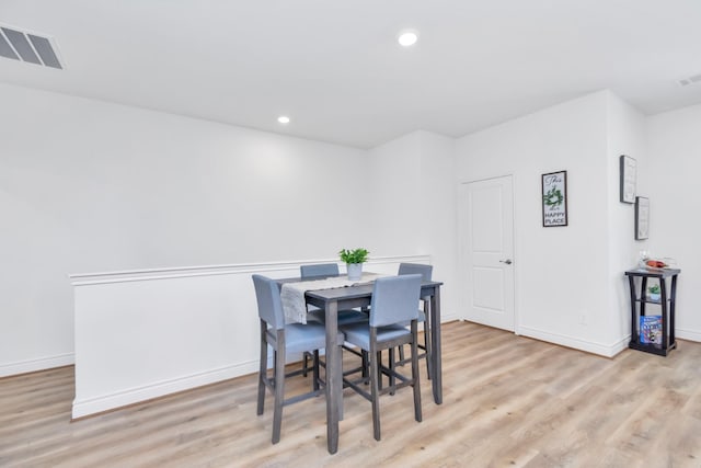 dining room featuring baseboards, light wood-type flooring, visible vents, and recessed lighting