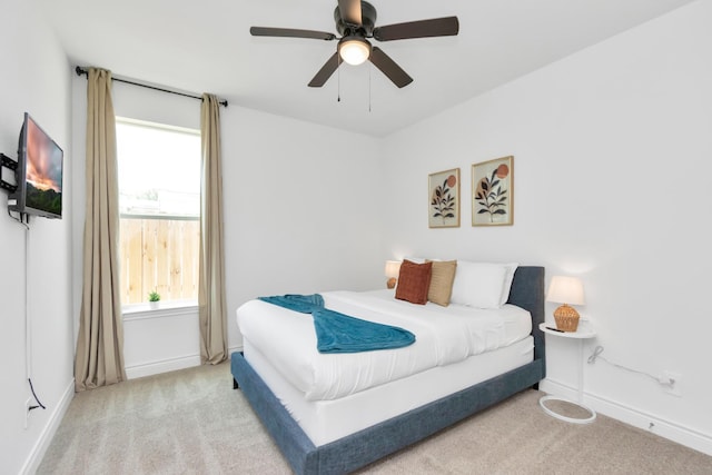 bedroom featuring baseboards, carpet floors, ceiling fan, and multiple windows