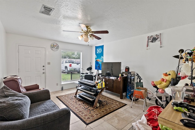 1520 Hillside Dr, College Station, TX 77845 - living room featuring a ceiling fan, visible vents, a textured ceiling, and light tile patterned floors