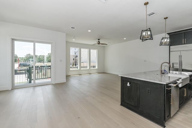 kitchen with plenty of natural light, light wood-style flooring, and dark cabinets