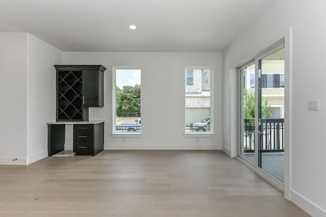 interior space with baseboards, light wood-type flooring, and recessed lighting