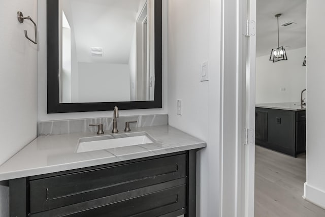 bathroom with visible vents, wood finished floors, and vanity