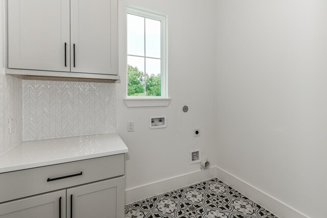 laundry room featuring hookup for a washing machine, baseboards, tile patterned floors, hookup for an electric dryer, and cabinet space