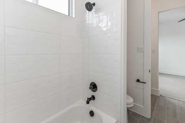 full bath with wood tiled floor, tub / shower combination, toilet, and baseboards