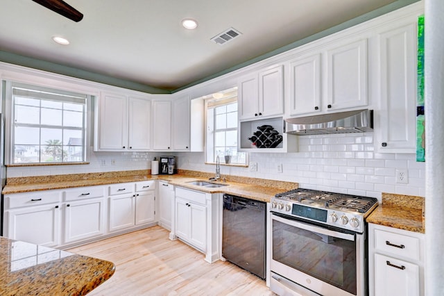 9605 Teichman Rd, Galveston, TX 77554 - kitchen with black dishwasher, under cabinet range hood, visible vents, stainless steel range with gas stovetop, and a sink