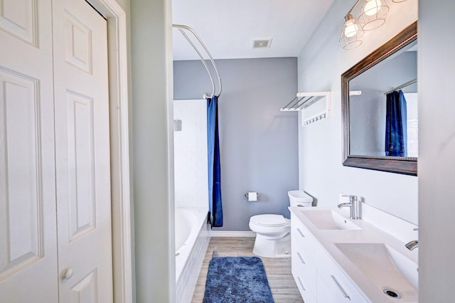 9605 Teichman Rd, Galveston, TX 77554 - full bath with a sink, visible vents, toilet, and wood finished floors