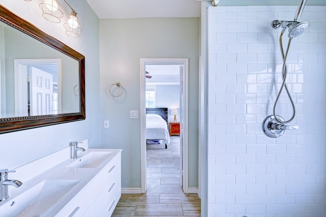 9605 Teichman Rd, Galveston, TX 77554 - bathroom featuring a tile shower, double vanity, and a sink