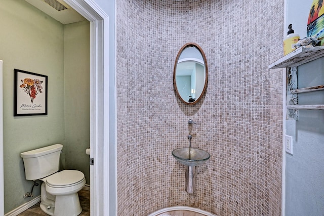 9605 Teichman Rd, Galveston, TX 77554 - bathroom featuring toilet, baseboards, and visible vents