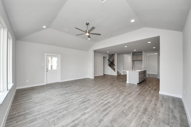12018 Maple Oak Dr, Houston, TX 77066 - unfurnished living room with lofted ceiling, stairs, ceiling fan, light wood-type flooring, and recessed lighting