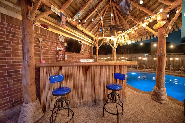 indoor dry bar with brick wall, carpet floors, beam ceiling, wood ceiling, and high vaulted ceiling