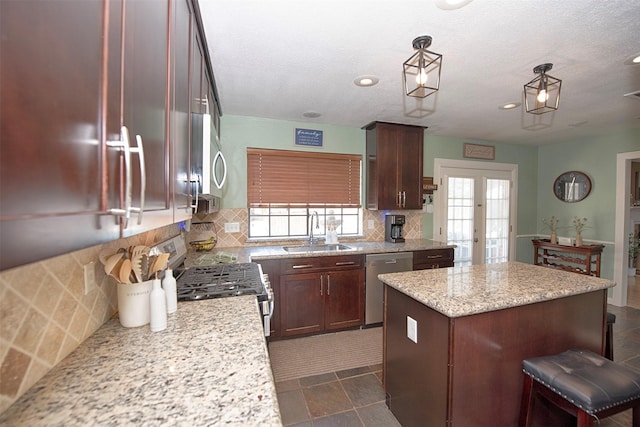 kitchen with a sink, appliances with stainless steel finishes, a center island, decorative backsplash, and healthy amount of natural light