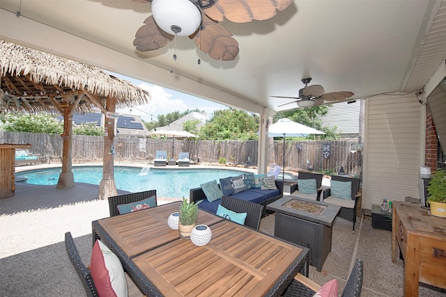 view of patio with ceiling fan, a fenced backyard, and an outdoor living space with a fire pit