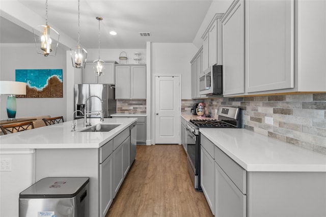 4831 Dove Cove Ln, League City, TX 77573 - kitchen featuring gray cabinetry, light countertops, light wood-style floors, and appliances with stainless steel finishes