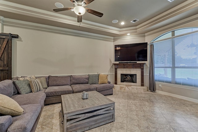 living area featuring a barn door, crown molding, and plenty of natural light