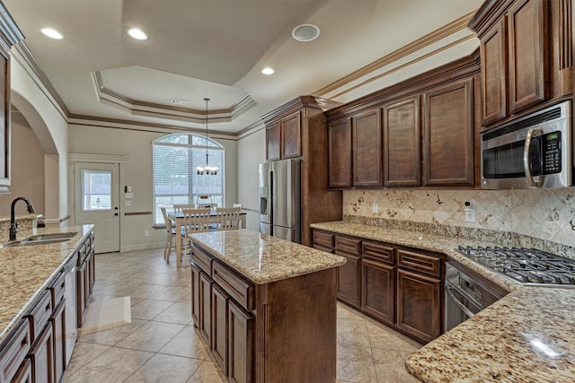 kitchen with stainless steel appliances, tasteful backsplash, arched walkways, a raised ceiling, and a sink
