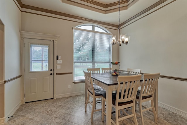 dining room featuring baseboards, a notable chandelier, a tray ceiling, and crown molding