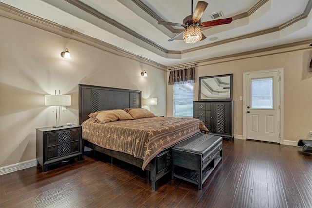 bedroom with a tray ceiling, visible vents, ornamental molding, and wood-type flooring