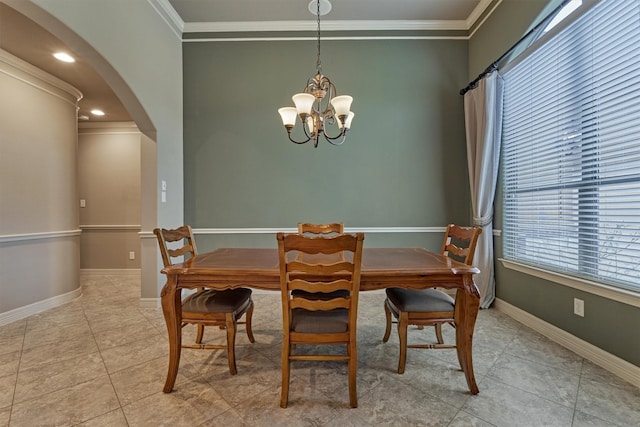 tiled dining room featuring ornamental molding, arched walkways, an inviting chandelier, and baseboards