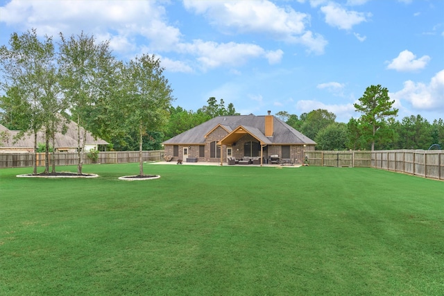 view of yard with a fire pit, a fenced backyard, and a patio area