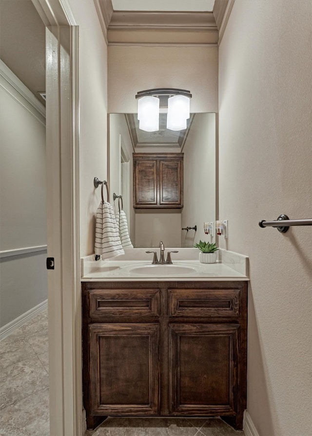 bathroom with baseboards, crown molding, and vanity