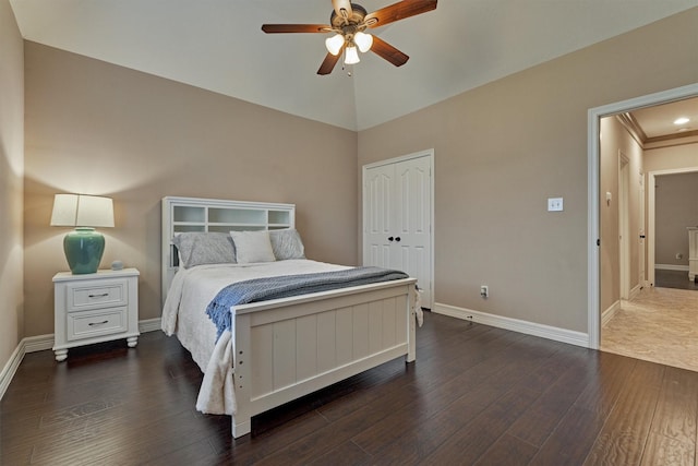 bedroom with vaulted ceiling, dark wood-style flooring, baseboards, a ceiling fan, and a closet