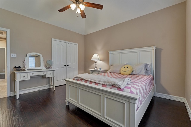 bedroom with baseboards, vaulted ceiling, a closet, and dark wood-type flooring