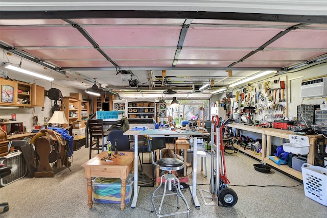 garage with a workshop area, a garage door opener, and a wall mounted air conditioner
