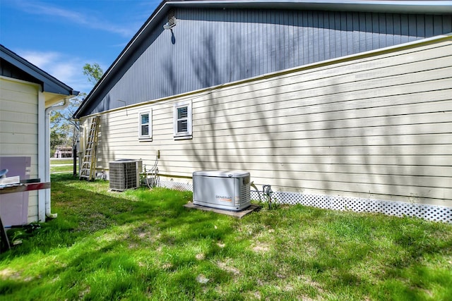 rear view of house featuring a yard and central air condition unit