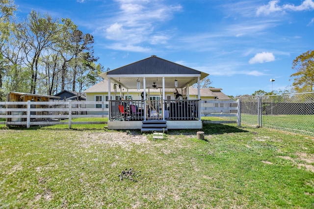 exterior space with a fenced backyard, a gate, a deck, and ceiling fan