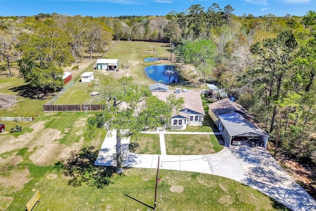 birds eye view of property with a view of trees and a water view