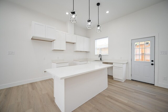 8203 Sparta St Unit B, Houston, TX 77028 - kitchen featuring a sink, light wood-style floors, pendant lighting, white cabinets, and a kitchen island