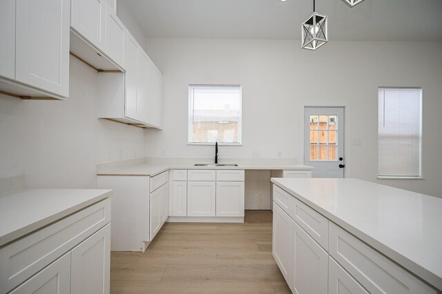 8203 Sparta St Unit B, Houston, TX 77028 - kitchen with a sink, light wood-style floors, pendant lighting, light countertops, and white cabinets