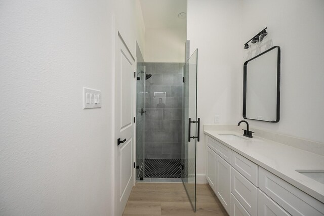 8203 Sparta St Unit B, Houston, TX 77028 - full bathroom with wood finished floors, a sink, double vanity, and a stall shower