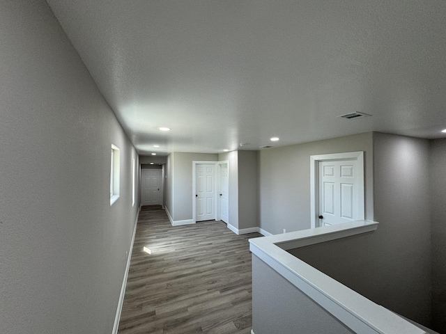 9805 Fabiola Dr, Houston, TX 77075 - hallway with wood finished floors, a textured ceiling, baseboards, visible vents, and recessed lighting