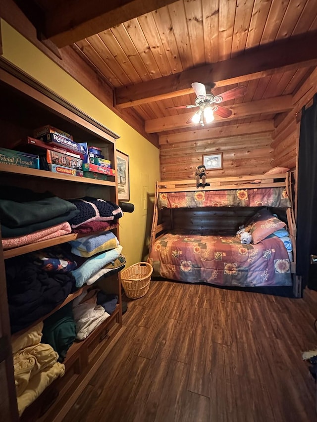 bedroom with wooden ceiling, beam ceiling, wooden walls, and wood finished floors