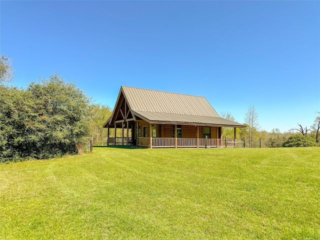 exterior space with a lawn, metal roof, covered porch, and log siding