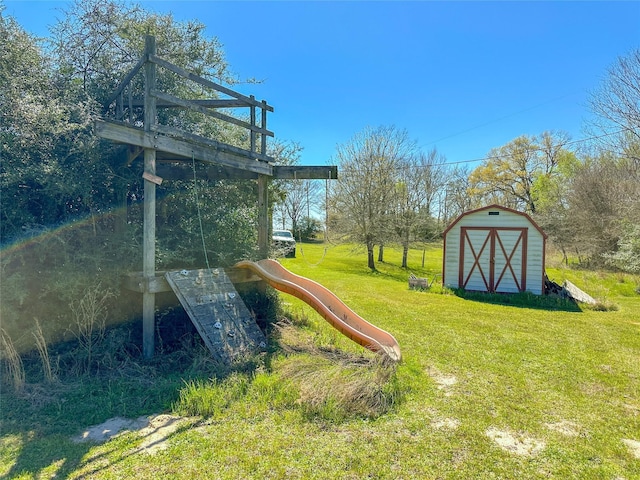 view of yard featuring an outbuilding, a storage unit, and a playground