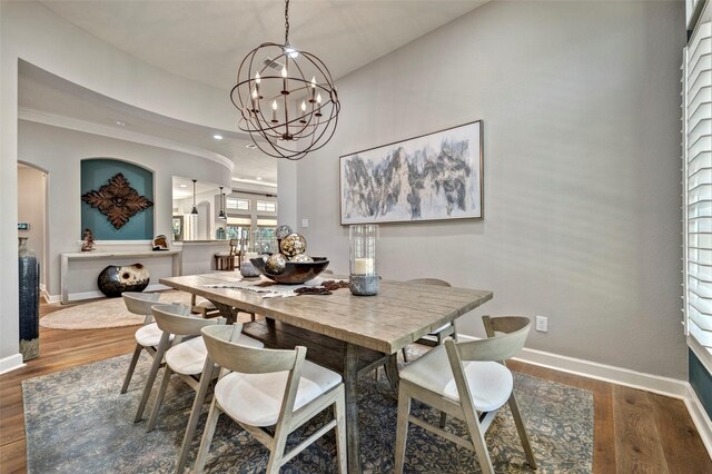 dining room with baseboards, a notable chandelier, and wood finished floors