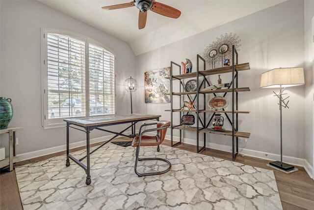 home office featuring baseboards, ceiling fan, wood finished floors, and vaulted ceiling