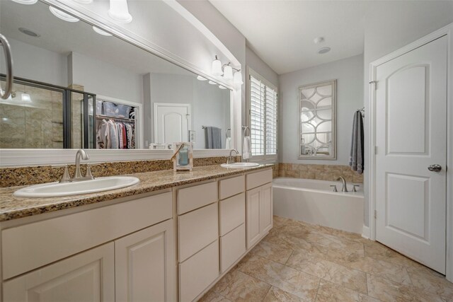 bathroom with a shower stall, double vanity, a bath, and a sink