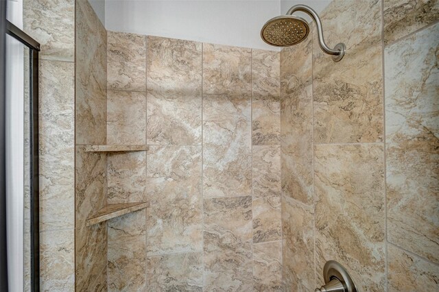 interior details featuring tiled shower