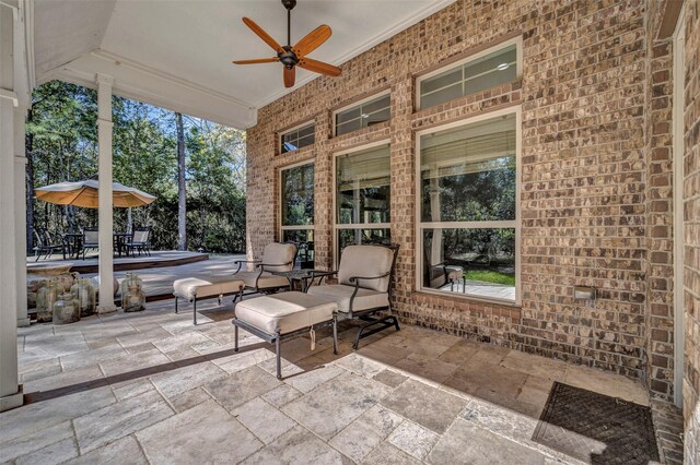 unfurnished sunroom with ceiling fan