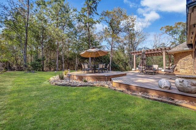 view of yard featuring a pergola, outdoor dining space, and a wooden deck