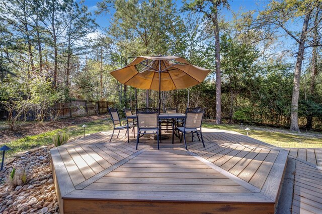 deck featuring outdoor dining area and fence