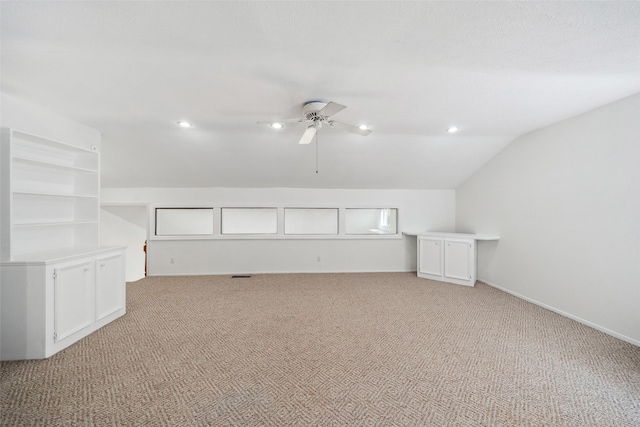 additional living space with a ceiling fan, lofted ceiling, light carpet, and baseboards
